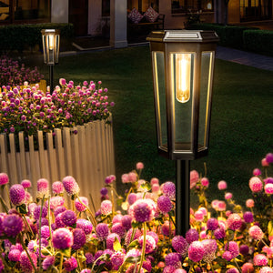 Dwellcozy outdoor salor pathway light fixture illuminating pink flowers in a well-maintained garden.